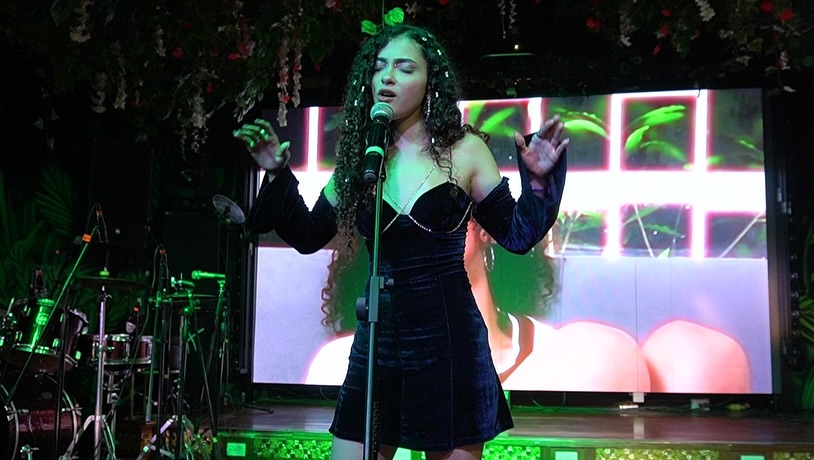 MARIALE cantando en vivo con vestido azul sobre el escenario